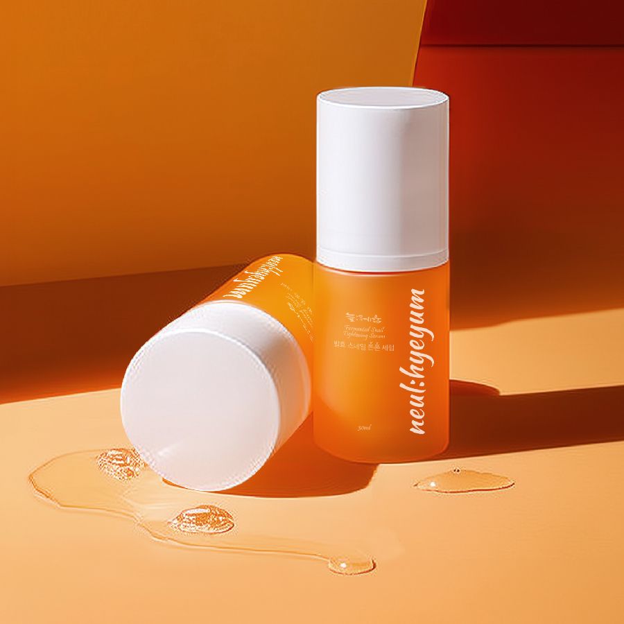 Zwei Flaschen. Eine aufrecht, eine liegend. Orangefarbene Flaschen mit weißem Deckel. Serum daneben.
