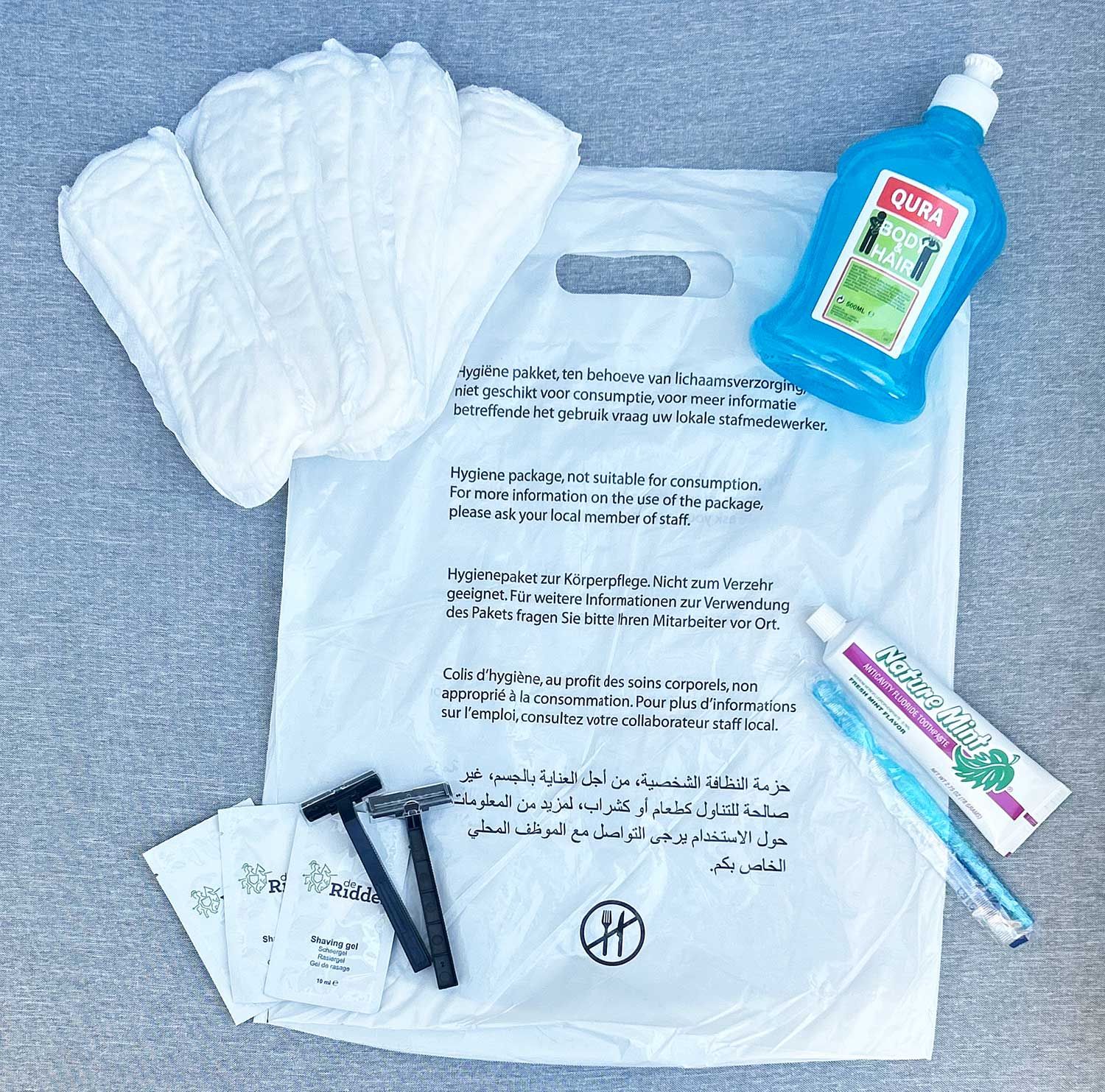 Hygieneartikel: Ein Beutel mit Slipeinlagen, Rasierern, Rasierschaum, Zahnbürste, Zahnpasta und Duschgel.