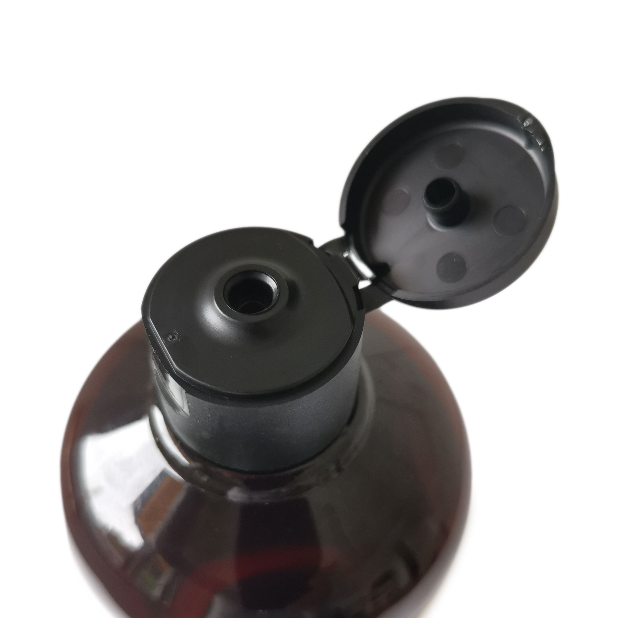 Nahaufnahme eines schwarzen Deckels auf einer braunen Flasche. Deckel ist geöffnet.