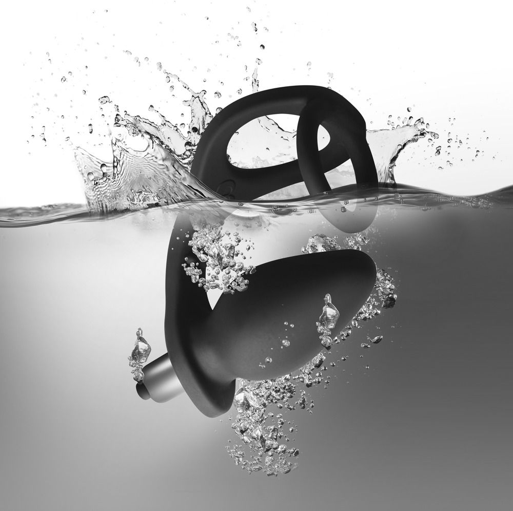 Schwarzer Penisring mit Plug im Wasser. Ringförmiger Teil und Plug-Teil mit Basis und metallischem Element. Wasser spritzt.