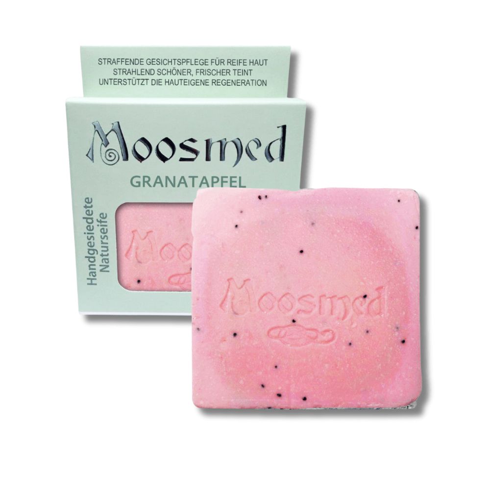 Rosa Seife mit schwarzen Punkten und Prägung. Verpackung mit Schriftzug Moosmed Granatapfel. Handgesiedete Naturseife.