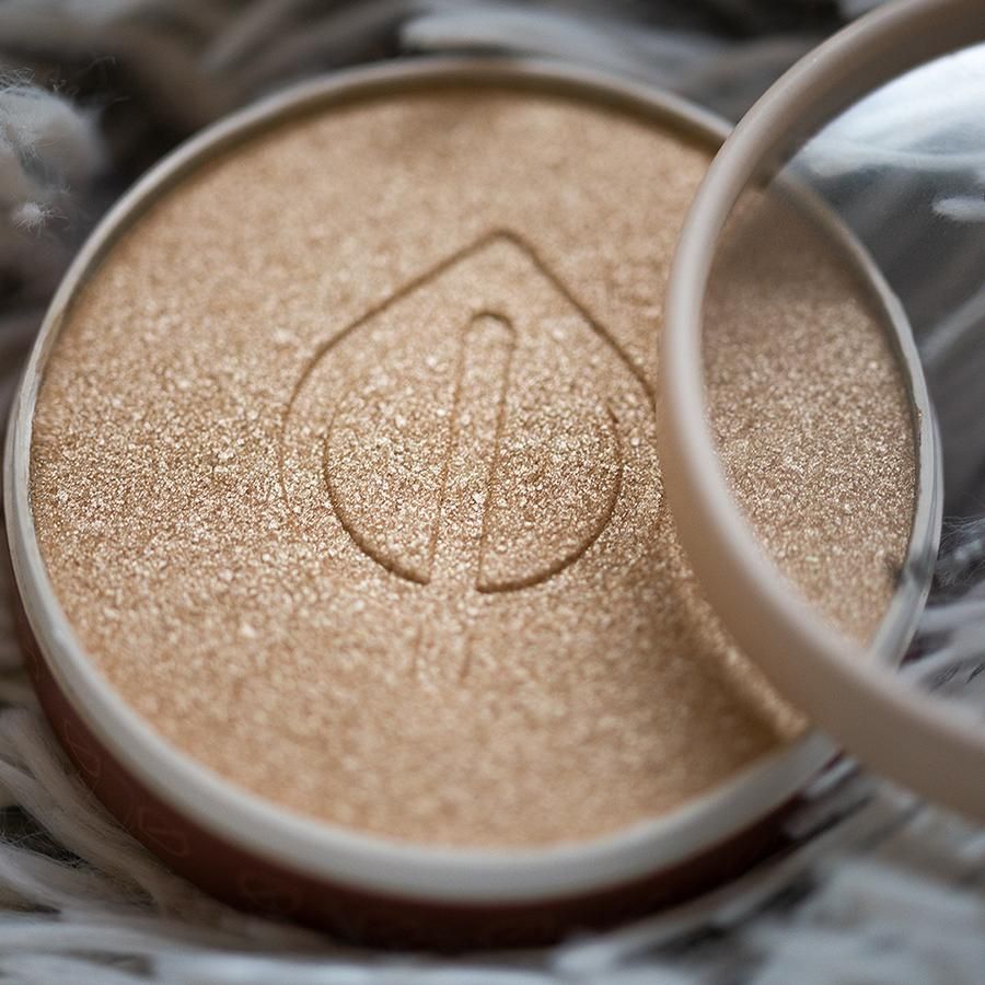 Goldener Highlighting Powder in runder Dose. Mit Spiegel. Geprägt mit einem Blatt-Logo.