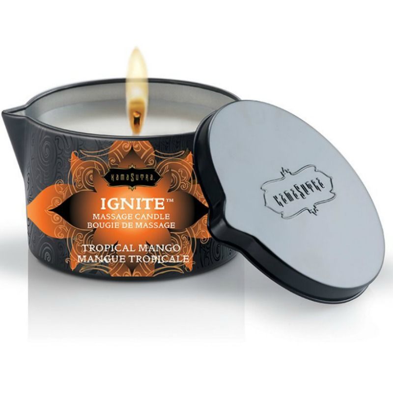 Geöffnete schwarze Dose mit brennender Kerze. Aufschrift: Kamasutra, Ignite Massage Candle, Tropical Mango. Deckel daneben.