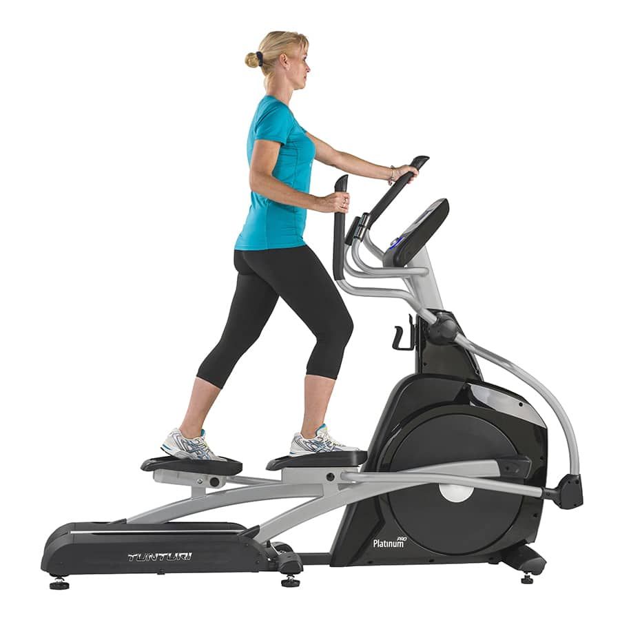 Crosstrainer in Gebrauch. Frau trainiert auf dem Gerät. Tunturi Platinum PRO sichtbar.