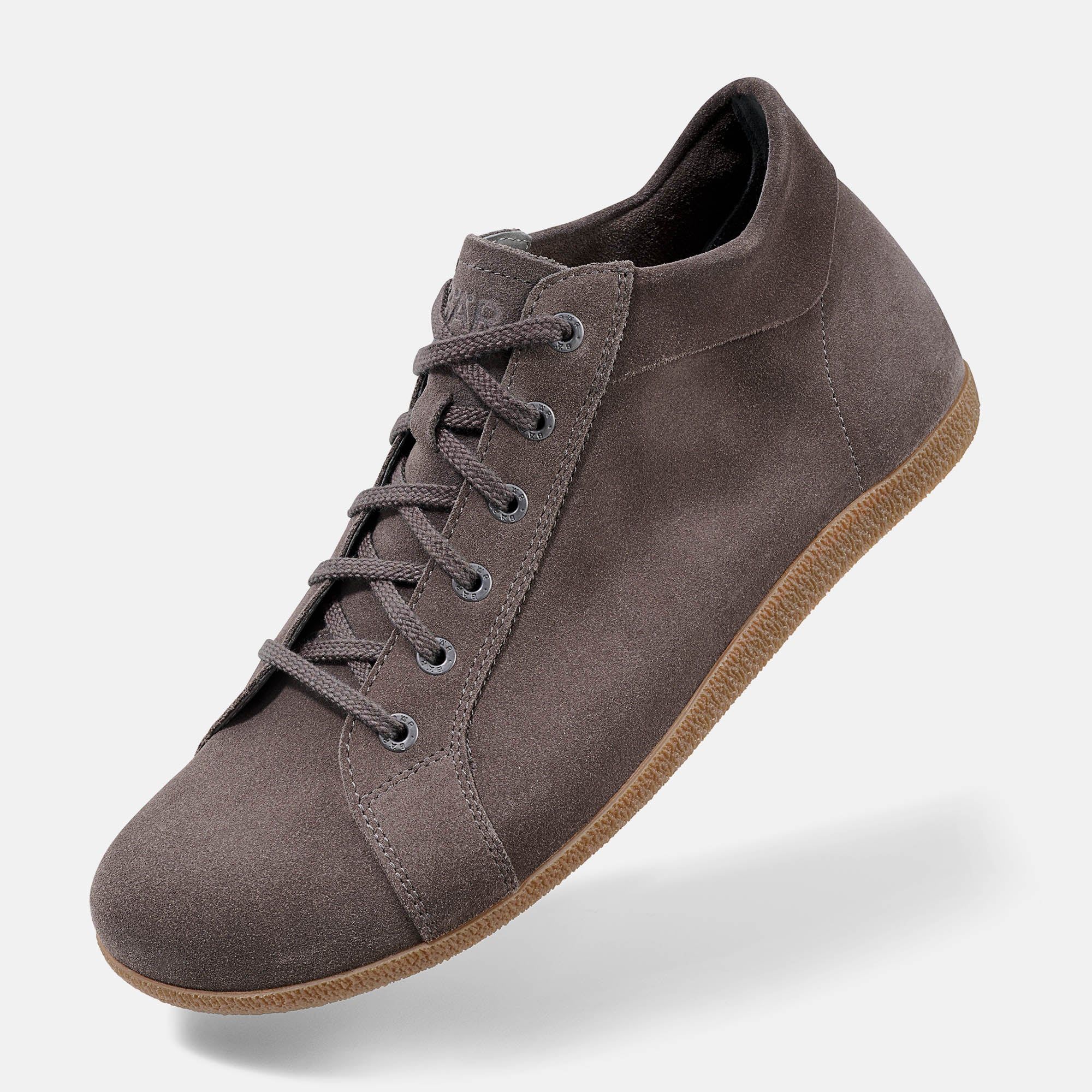 Braune Stiefelette aus Wildleder. Schnürung, helle Sohle. Seitlicher Schnitt, flache Form.