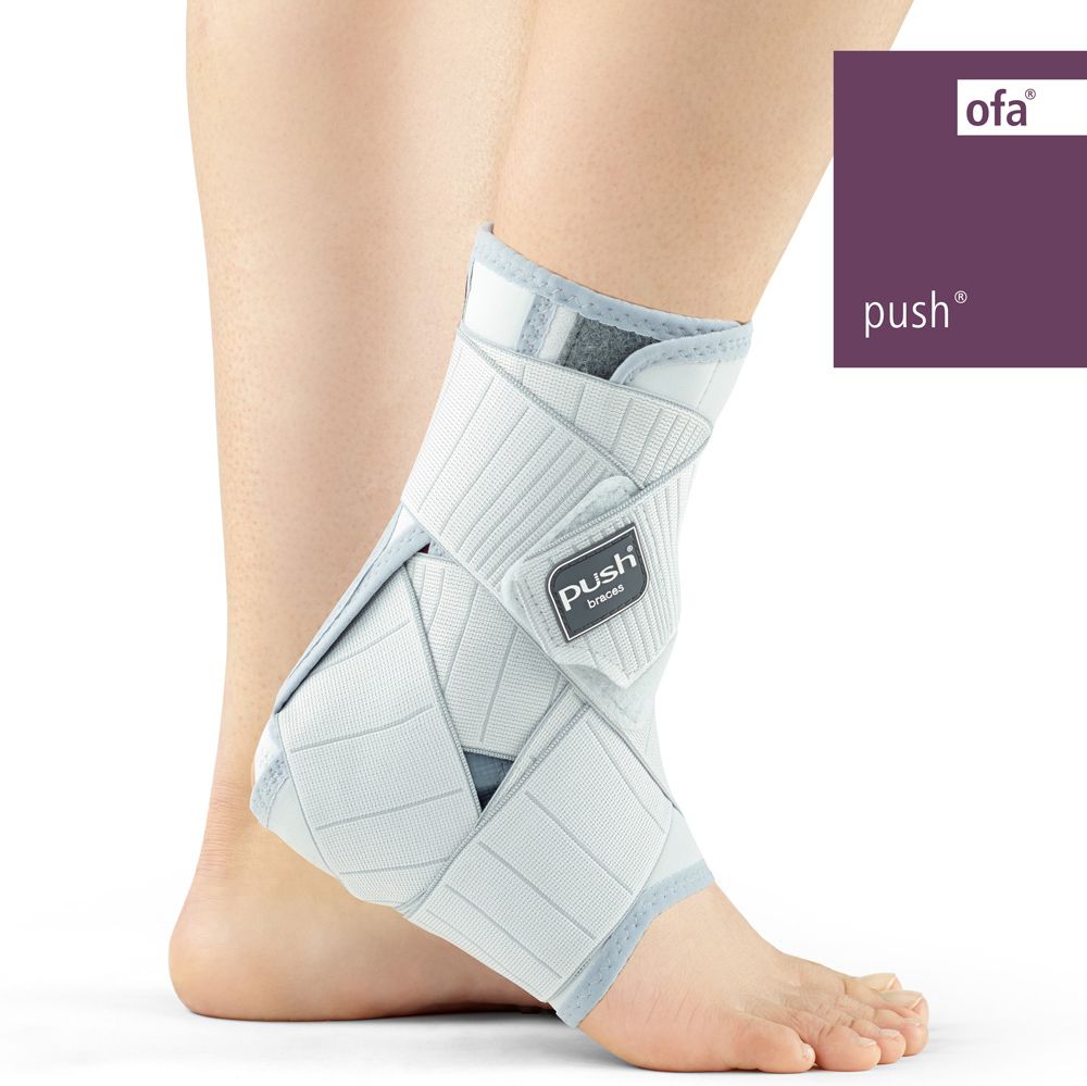 Push med Knöchelbandage am linken Fuß, weiß und grau mit Klettverschlüssen.