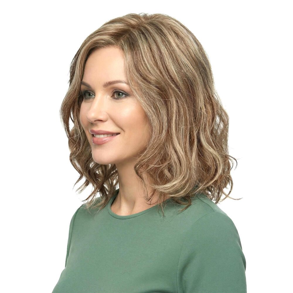 Perücke mit gewelltem, blond-braunem Haar. Frau trägt ein grünes Oberteil. Seitenansicht.