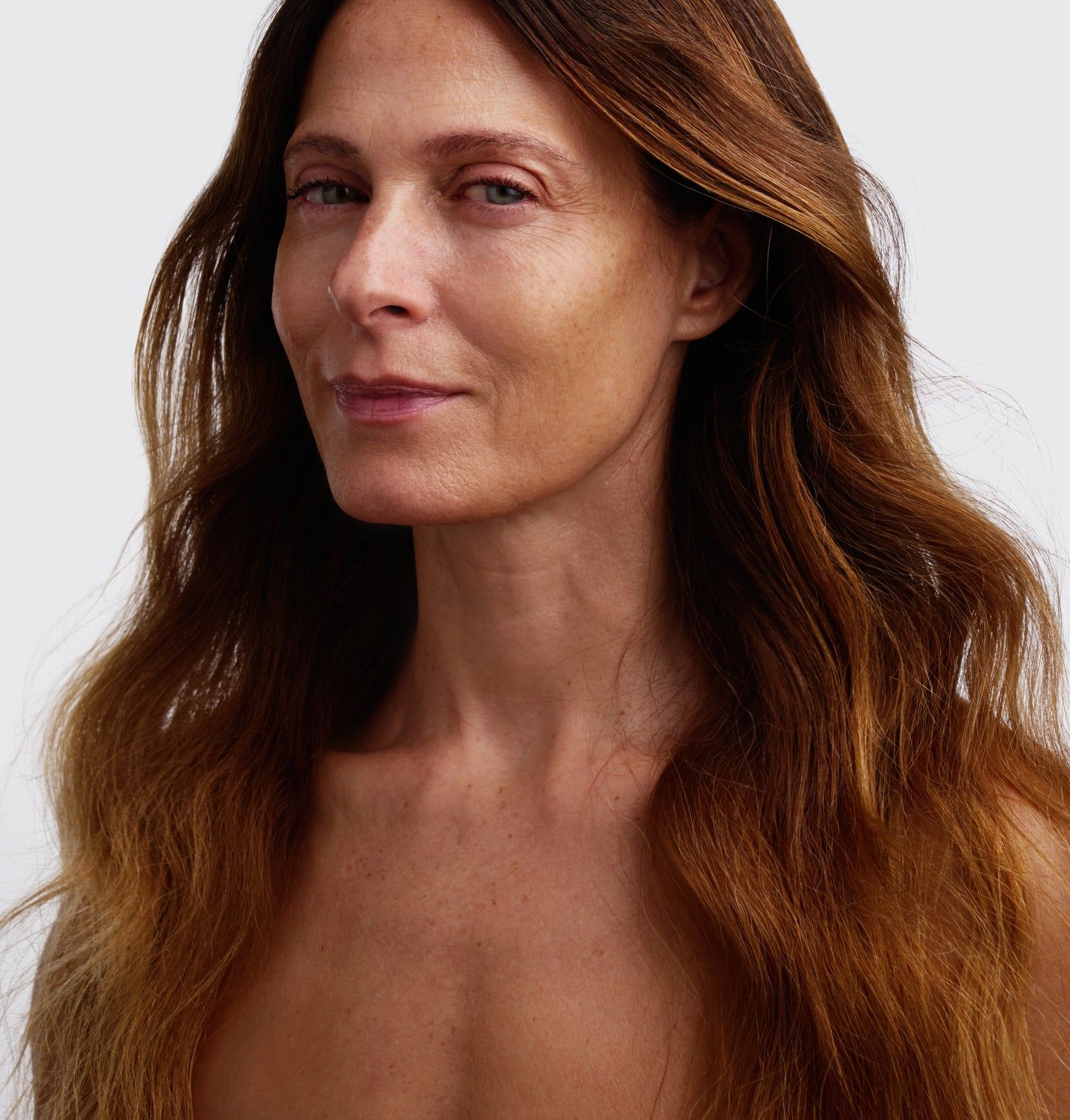 Porträt einer Frau mit langen, braunen Haaren. Sie blickt in die Kamera. Natürliche Hautfarbe.