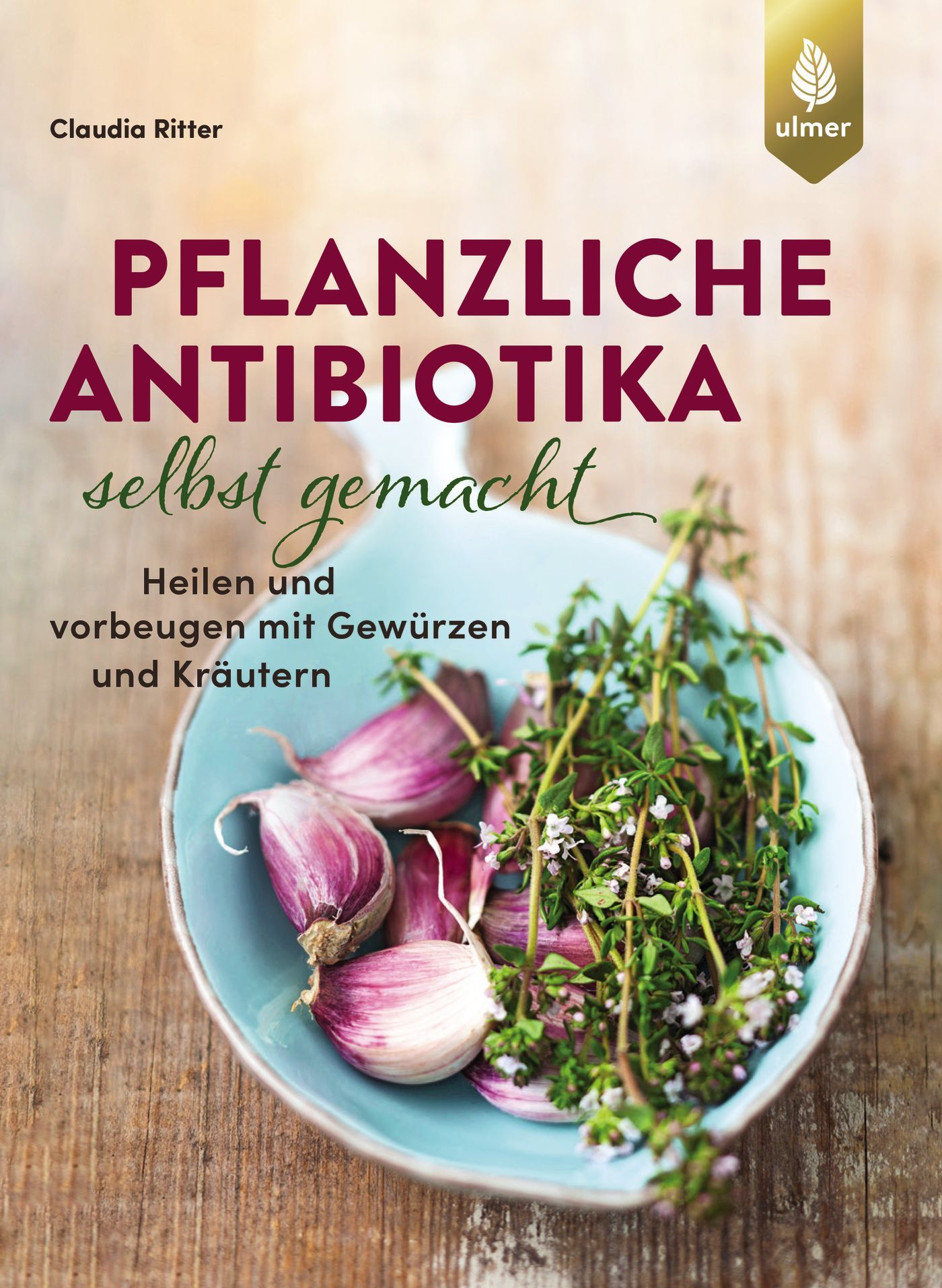 Buchcover mit Titel: Pflanzliche Antibiotika selbst gemacht. Autorin: Claudia Ritter. Logo Ulmer. Auf blauem Teller Knoblauch und Kräuter.