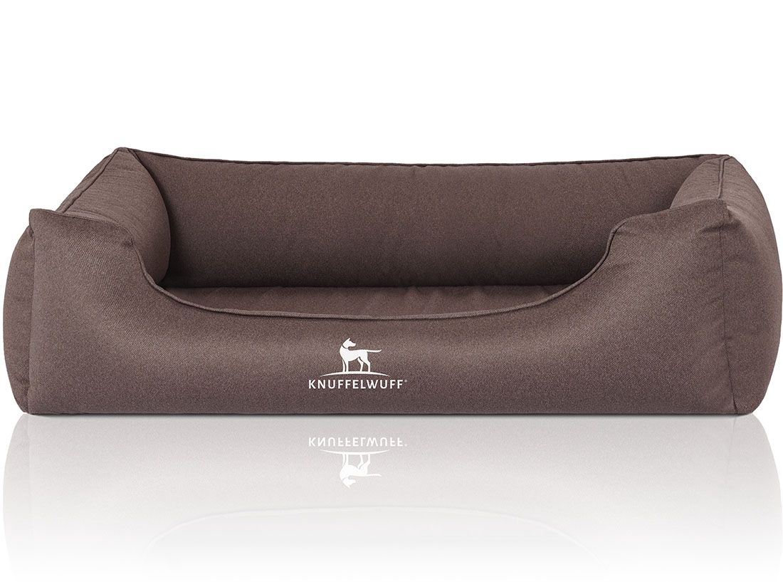 Braunes Hundebett mit erhöhtem Rand. Logo: Knuffelwuff. Rechteckige Form, weiches Material. Reflektion auf weißem Untergrund.