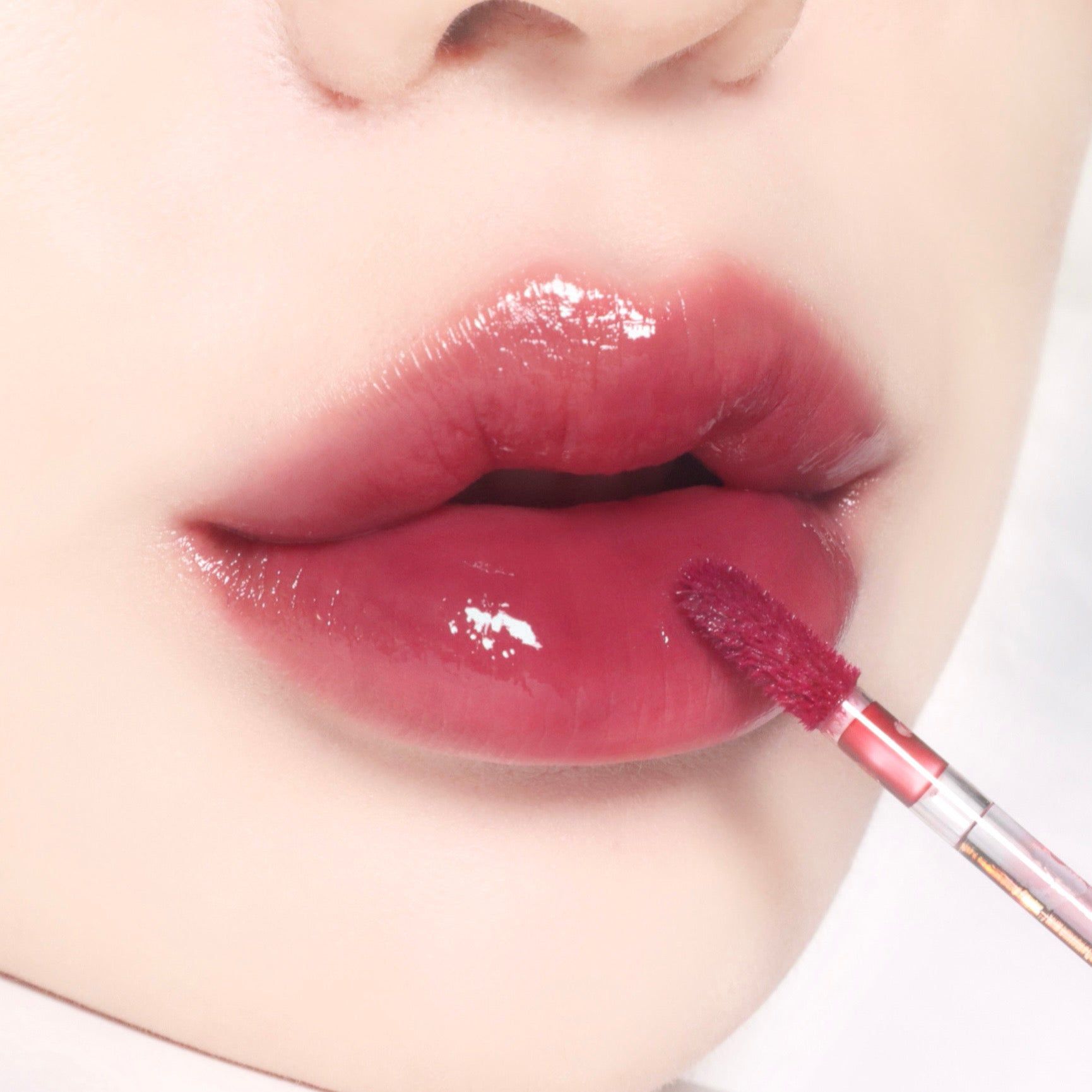 Nahaufnahme von Lippen mit BBIA Glow Lip Tint 03 Mauve. Applikator in Gebrauch.