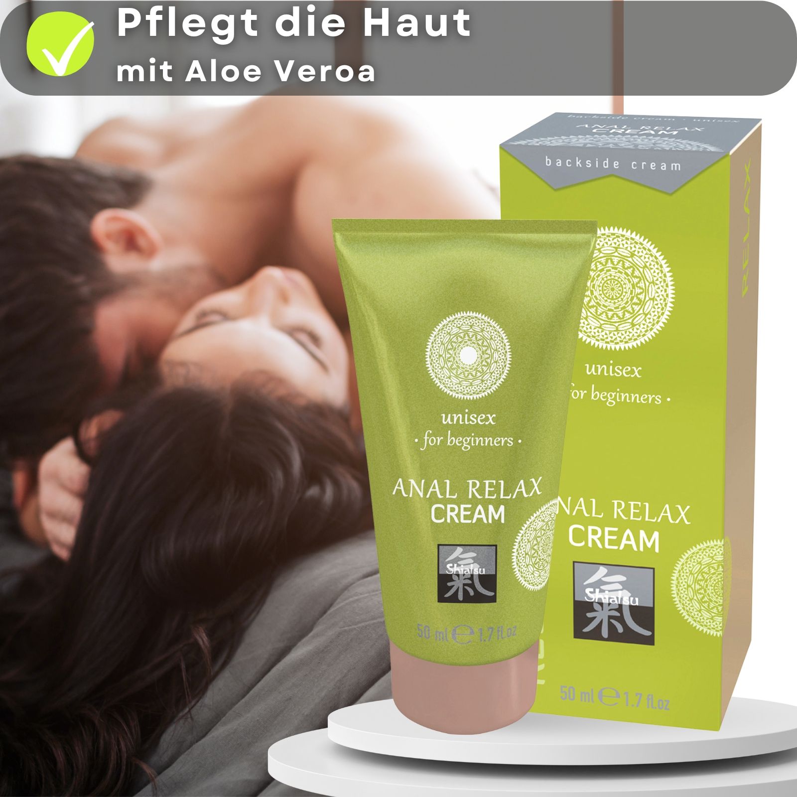 Grüne Tube und Schachtel. Text: ANAL RELAX CREAM, unisex for beginners. Logo. Rosa Kappe. 50 ml. Paar im Hintergrund.
