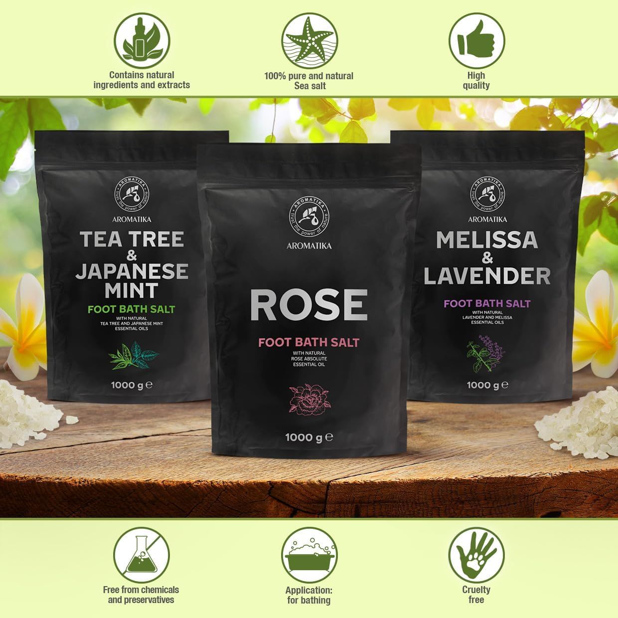 Drei schwarze Beutel Fußbadesalz auf einem Holztisch. Aufschrift: Tea Tree & Japanische Minze, Rose, Melisse & Lavendel. Marke: AROMATIKA. 1000 g.