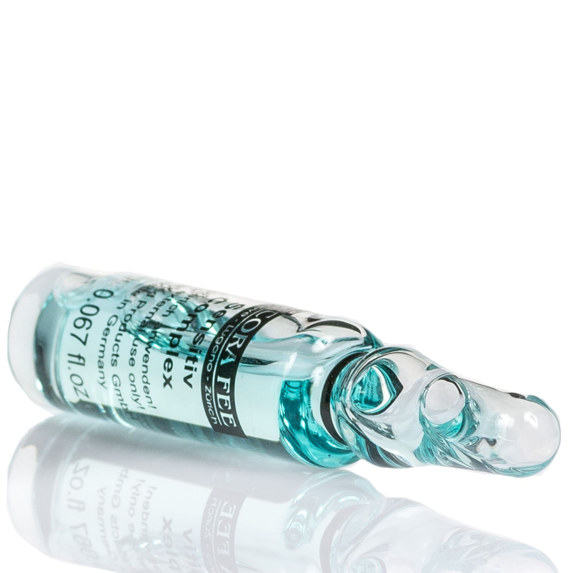 Glasampulle mit bläulicher Flüssigkeit. Produktname und Logo auf dem Etikett. Ampulle liegt auf weißem Untergrund.