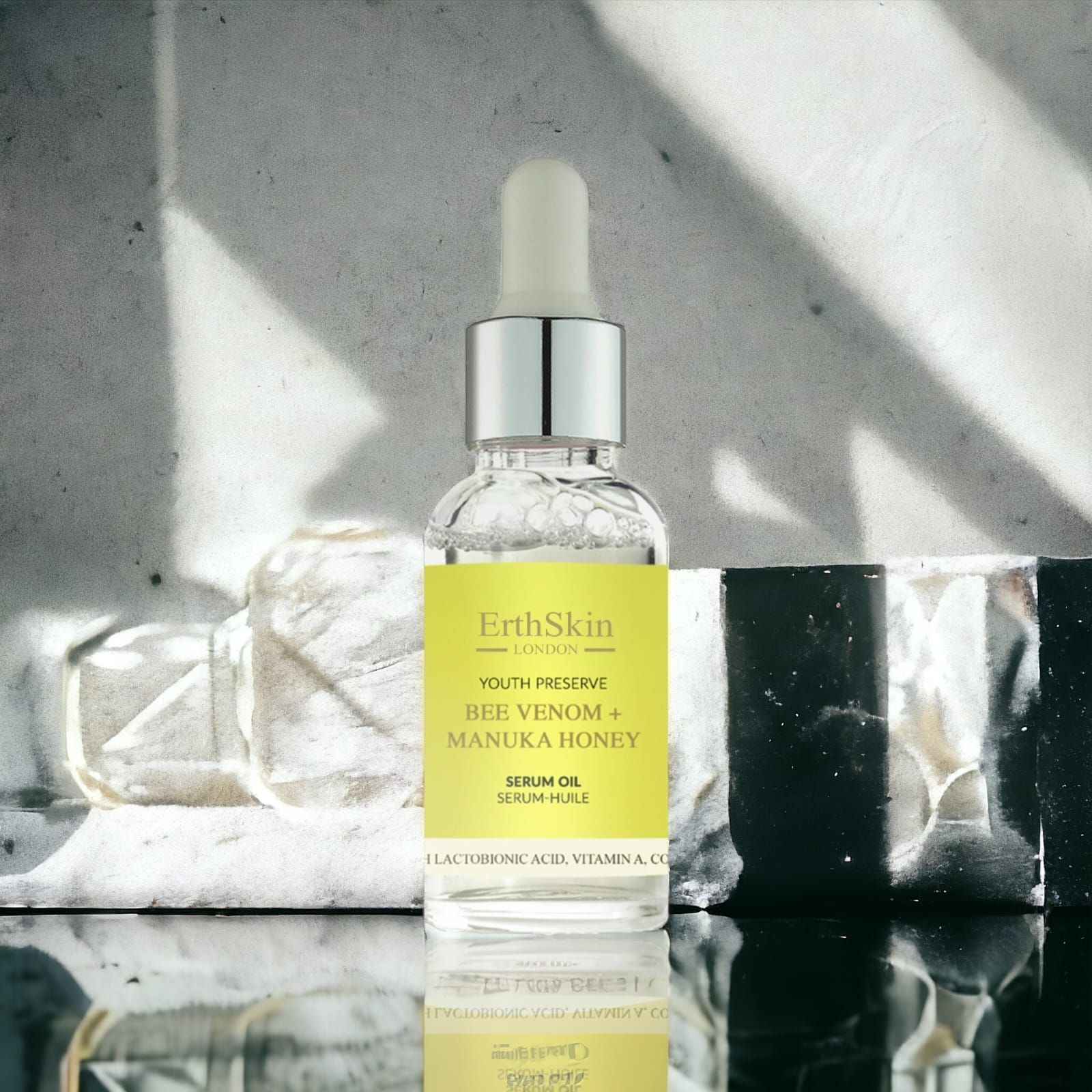 ErthSkin London Serumflasche mit gelbem Etikett. Enthält Bienenvenen und Manuka-Honig. Mit Pipette. Auf einer Oberfläche.