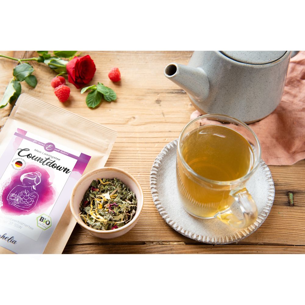 Teebeutel, Teetasse, Teekanne und Zutaten auf Holzoberfläche. Produkt: Mein Lieblingstee Countdown.