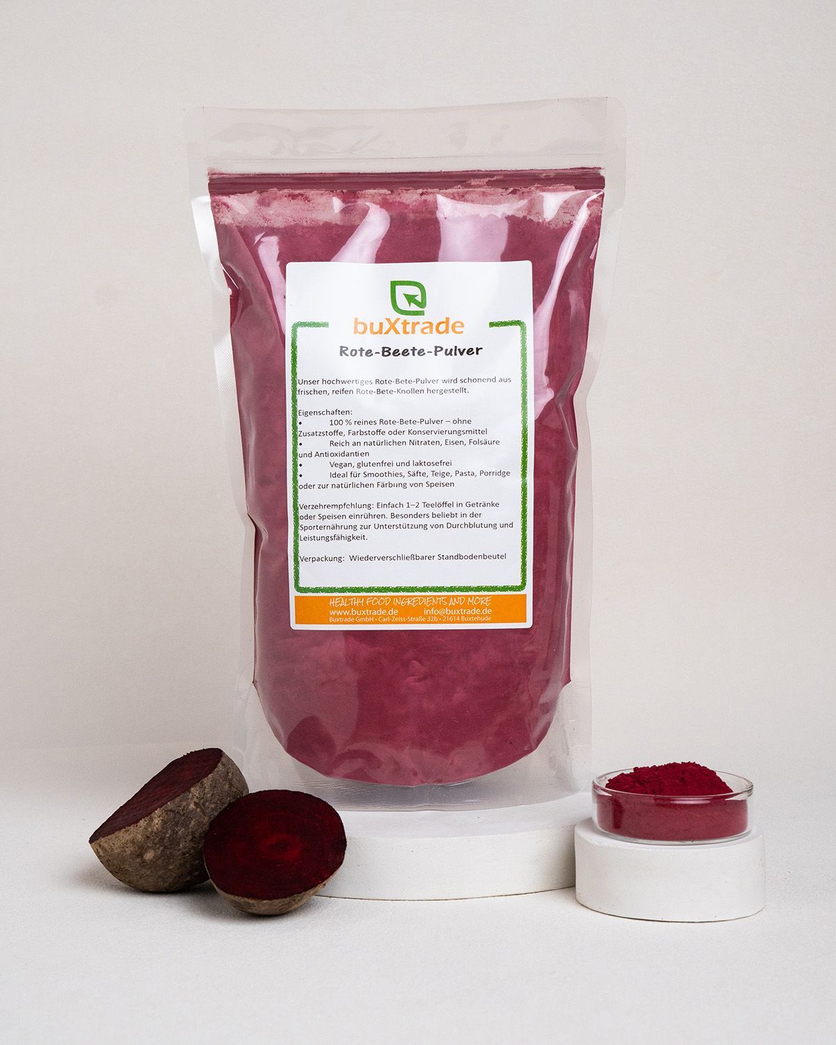Rote Bete, halbiert, daneben Pulver in Schale. Verpackung mit Etikett.
