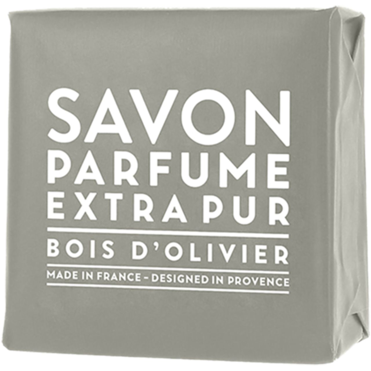 Graues Seifenstück in Papier verpackt. Text: Savon Parfume Extra Pur Bois d'Olivier. Hergestellt in Frankreich, entworfen in der Provence.