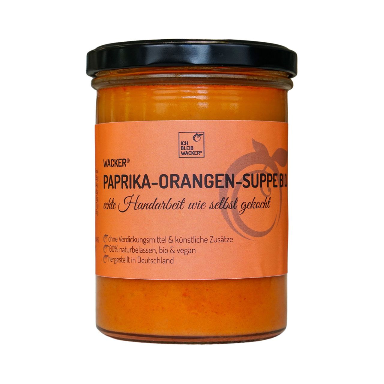 Glas mit Paprika-Orangen-Suppe. Orangefarbene Suppe mit Etikett. Text: Wacker, Paprika-Orangen-Suppe, echte Handarbeit.