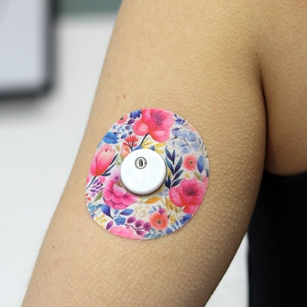 Arm mit rundem Pflaster. Blumenmuster, Loch in der Mitte. Sensor in der Mitte des Pflasters.