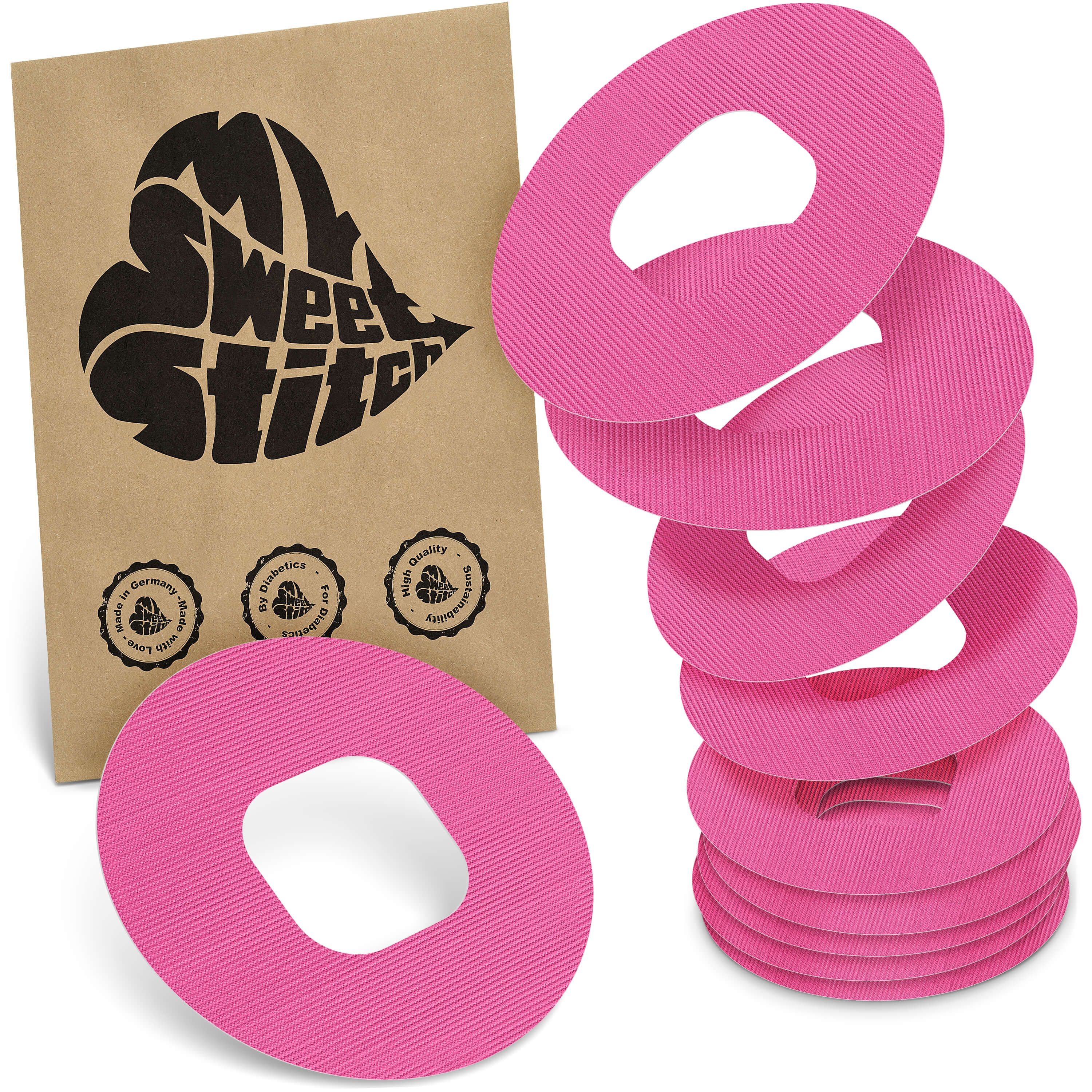 Rosa Ringpflaster, geriffelt, mit ovaler Aussparung. Neben Packung mit Logo 'MySweetStitch'.