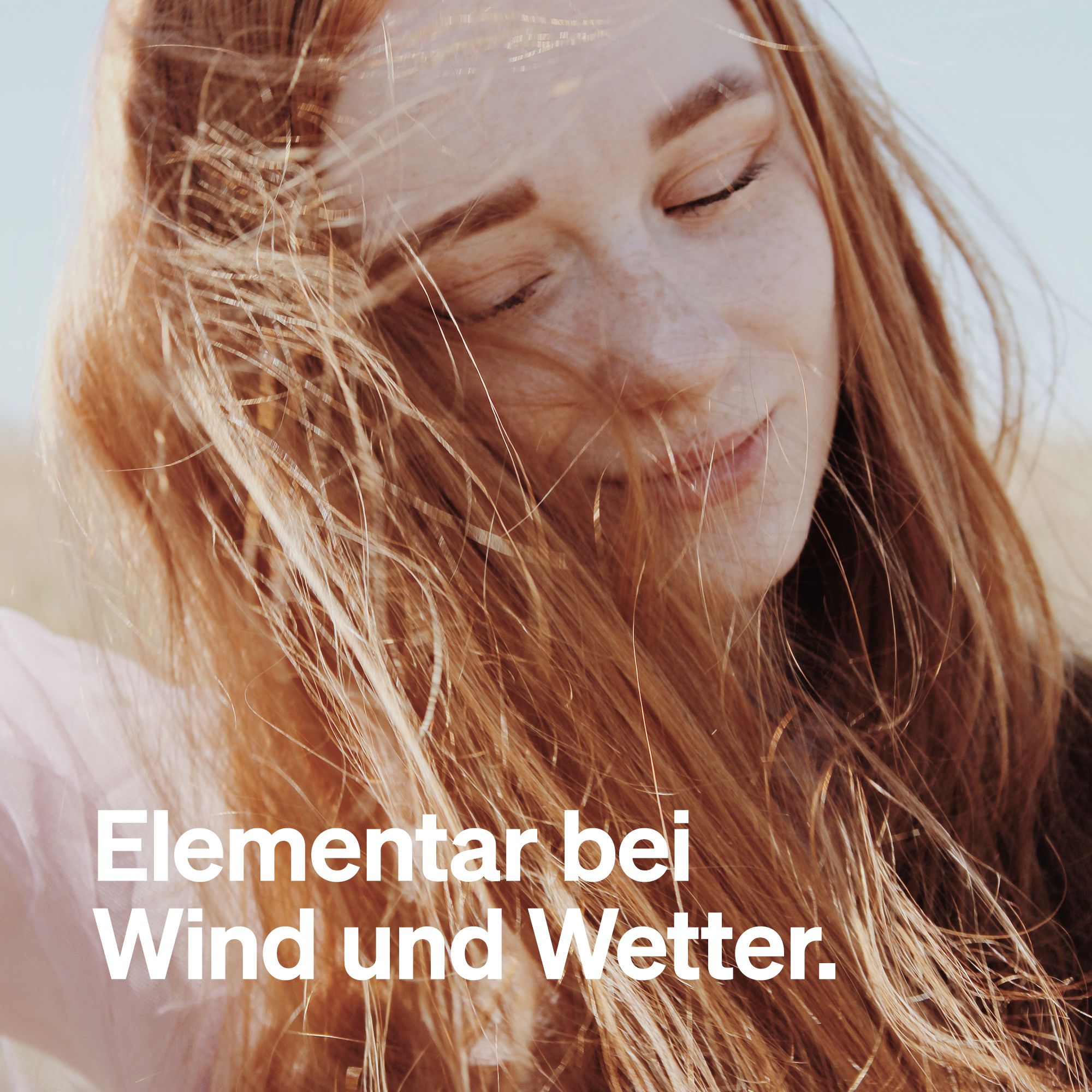 Porträt einer Frau mit roten Haaren. Text: Elementar bei Wind und Wetter.