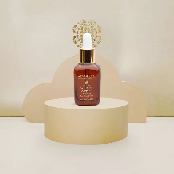 Braune Flasche mit goldener Pipette. Aufschrift: Arganicare, Organic Wheat Germ Pure Oil. Auf Podest.