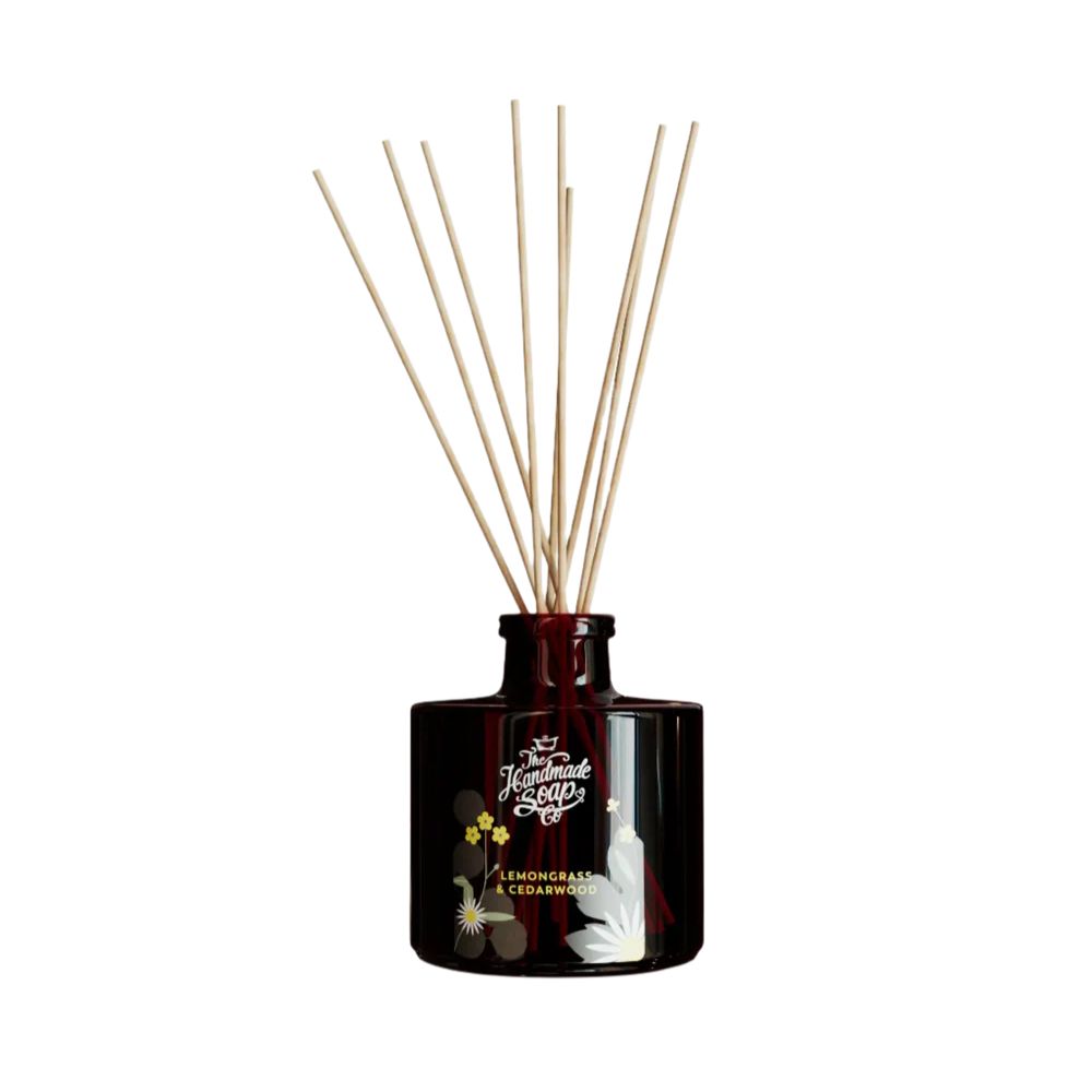 Braune Glasflasche mit Holzstäbchen. Aufschrift: The Handmade Soap Company, Zitronengras & Zedernholz. Floral-Dekor.