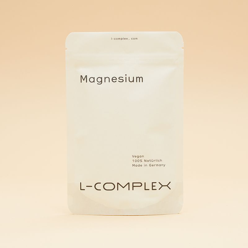 Weißer Beutel mit Aufschrift Magnesium. Vegan, 100% natürlich, Made in Germany. L-COMPLEX Logo. Cremefarbener Hintergrund.