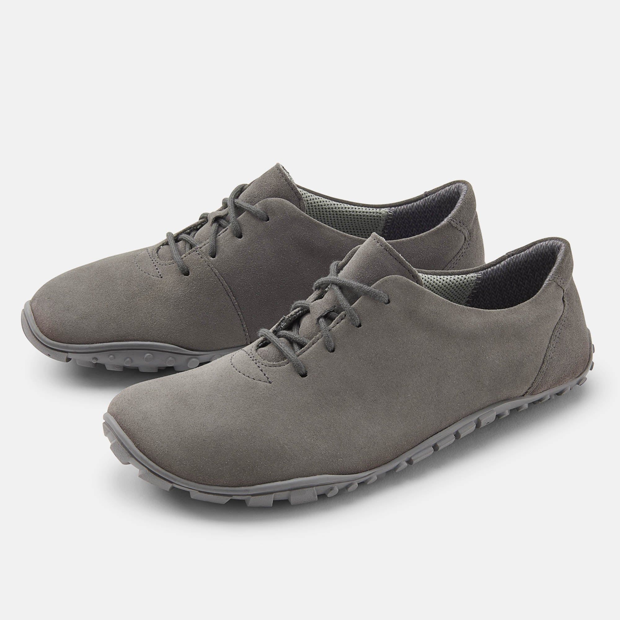 Graue Schnürschuhe. Obermaterial aus Wildleder. Breite Sohle mit Profil. Zwei Schuhe nebeneinander, leicht schräg gestellt.