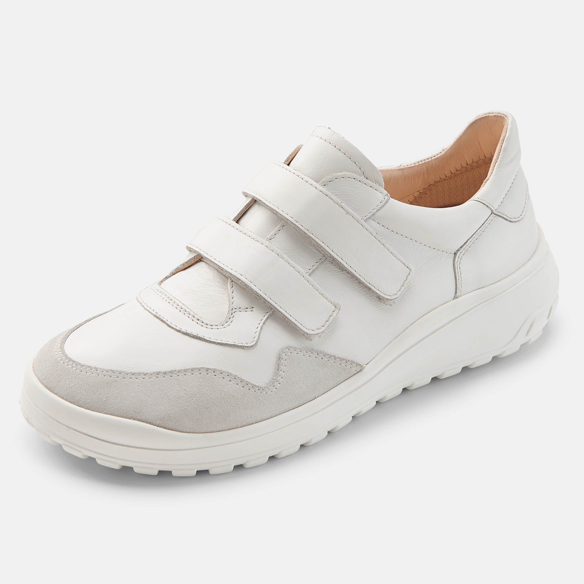 Weißer Herren-Slipper mit Klettverschluss. Graue Akzente an der Spitze. Breite Passform. Schuh von der Seite.