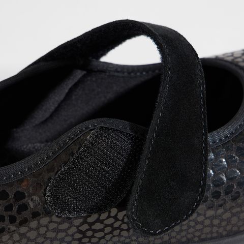 Schwarze Damenschuhe mit Klettverschluss und gemustertem Obermaterial.