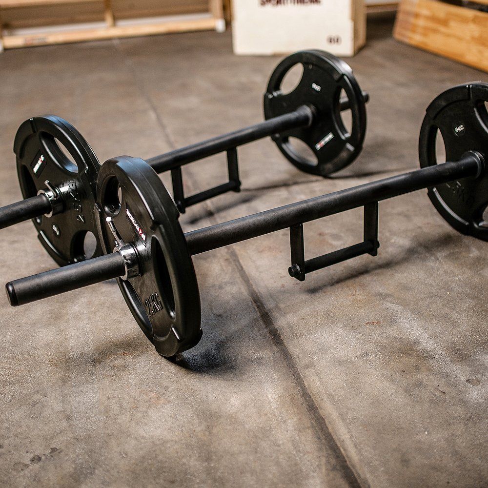 Zwei Farmers Walk Bars mit Gewichten. Schwarze Stangen mit Griffen und Gewichtsscheiben. Auf Betonboden.