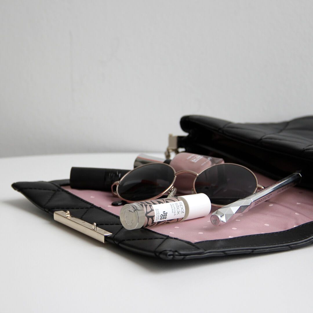 Spot Stick und Zubehör in einer Handtasche.  Braune und weiße Verpackung.  Markenname und Text sichtbar.
