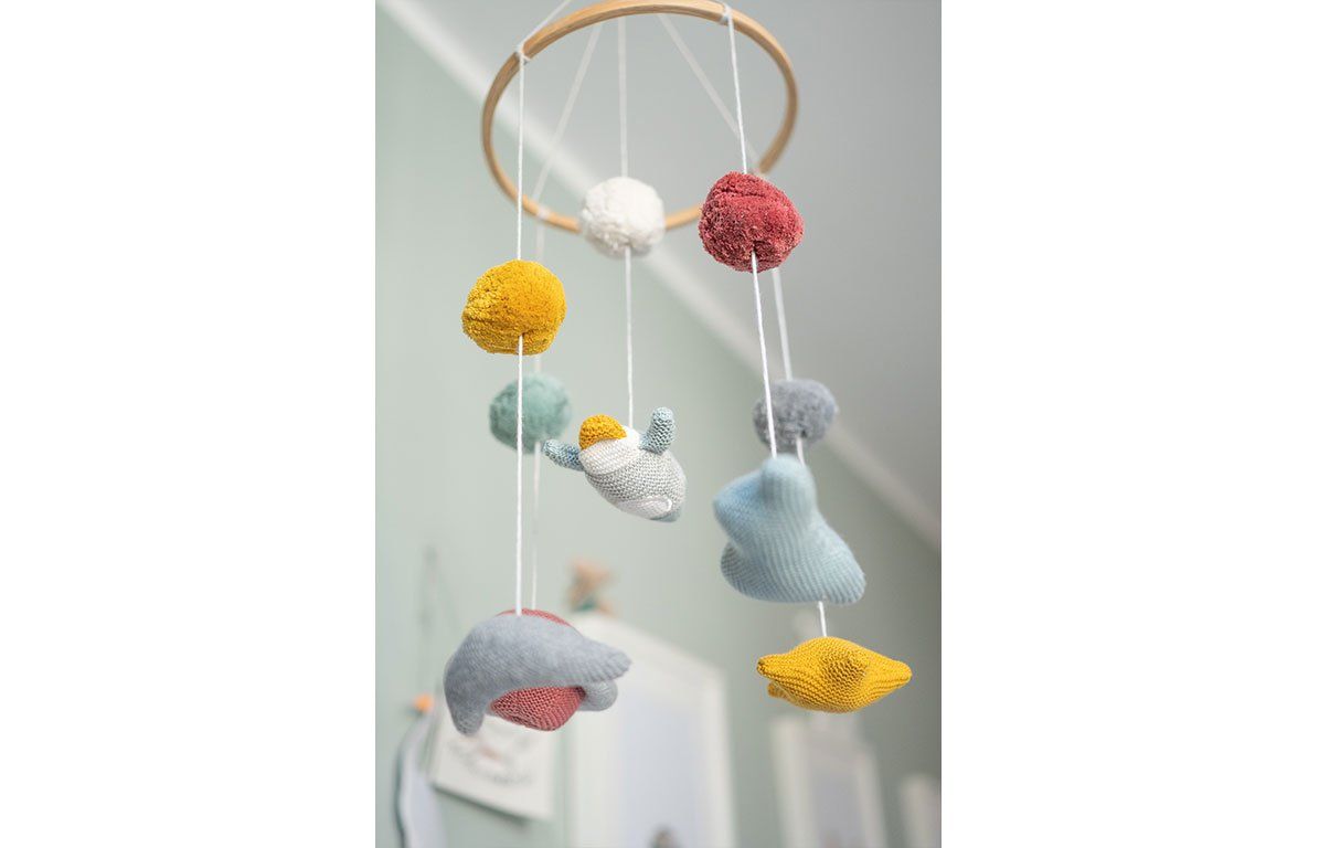 Mobile mit Holzring und bunten Elementen: Kugeln, Sterne und Planeten. Aufhängung an Fäden.