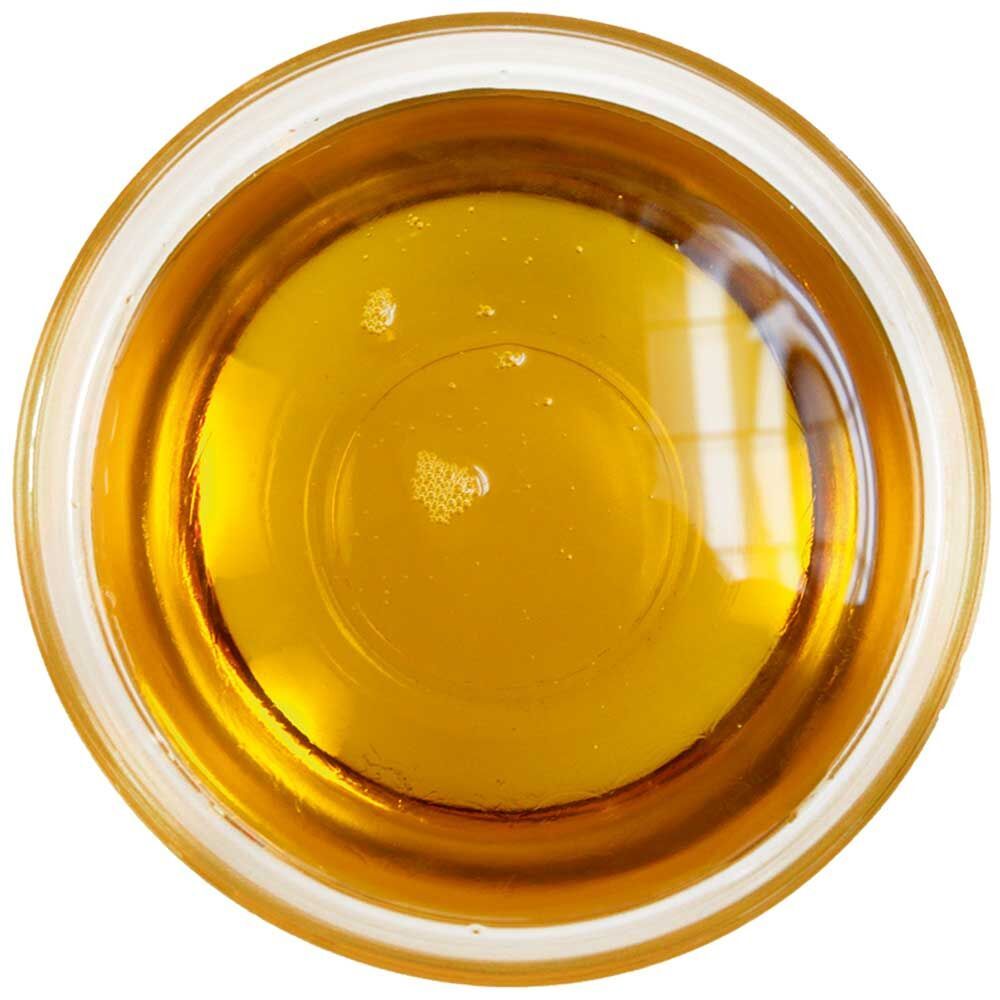 Klare Glasschale mit gelbem Öl. Reflexionen im Öl. Runde Form.