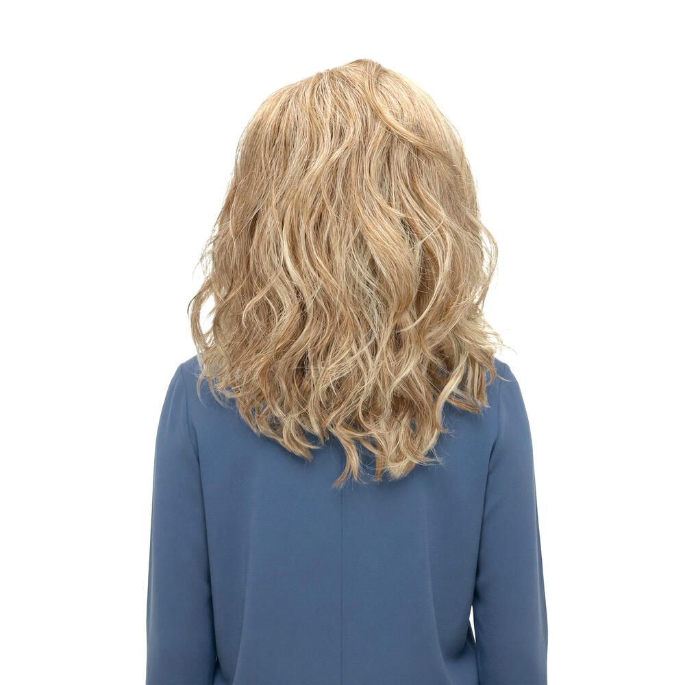 Rückansicht einer Frau mit blond gewellter Perücke. Die Perücke hat blonde und hellbraune Strähnen.