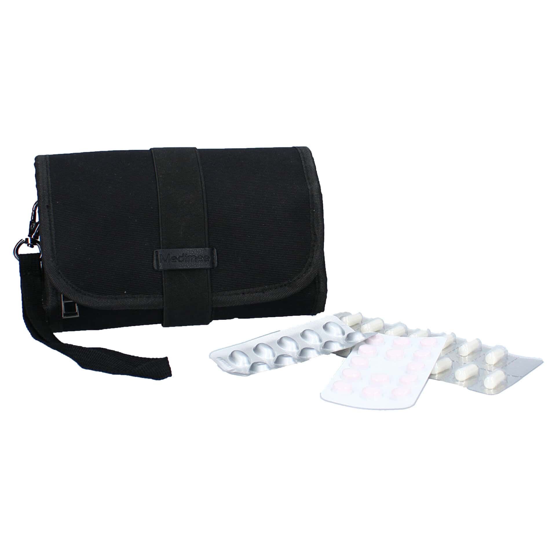 Schwarzes Medikamenten-Etui mit zwei Blistern mit Pillen daneben.