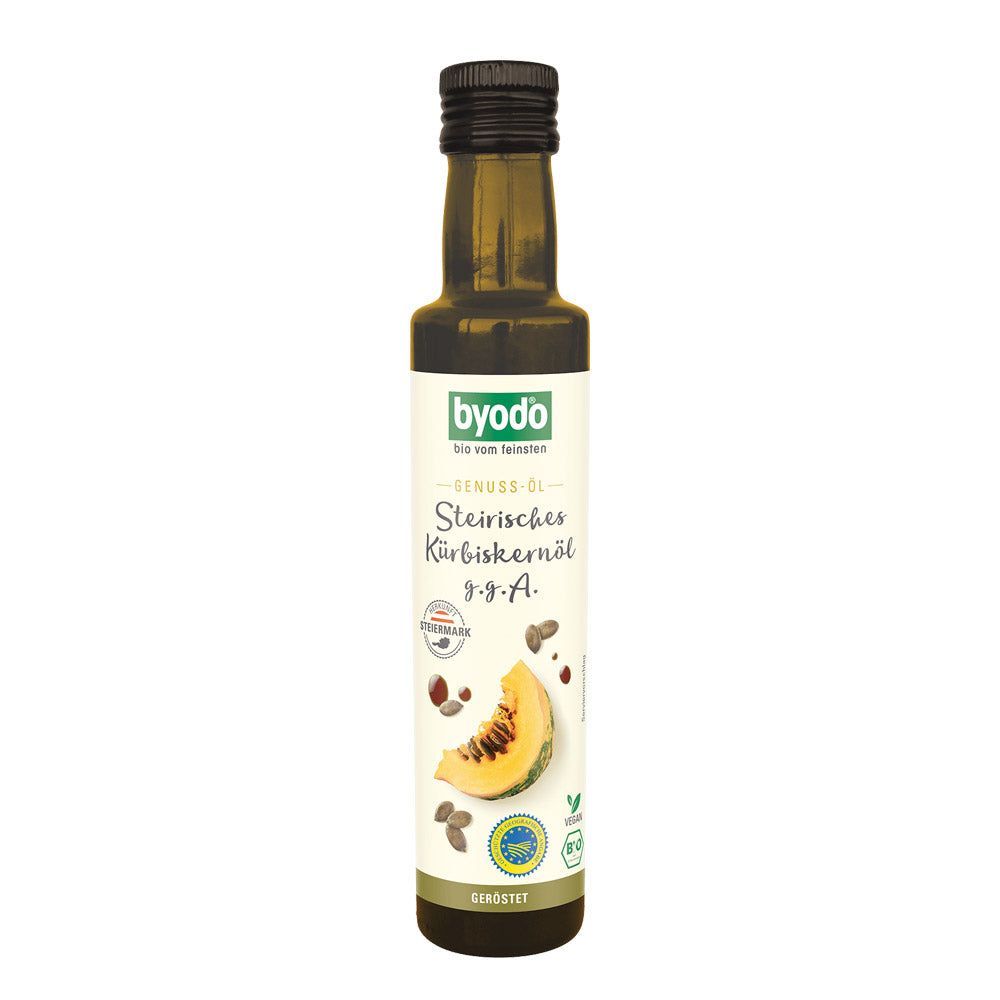 Grüne Glasflasche mit schwarzem Deckel. Etikett mit Produktname und Kürbis-Illustration. Vegan-Siegel.