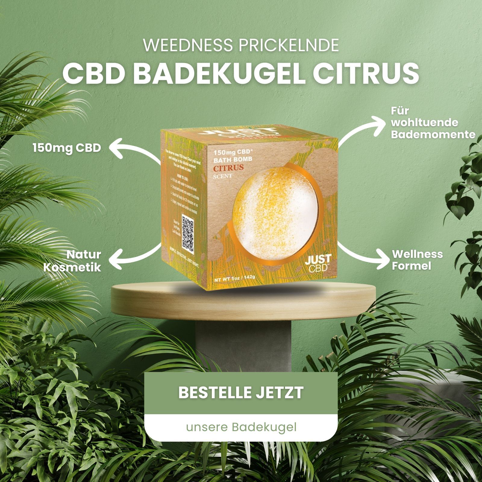 Karton mit CBD-Badebombe. Aufschrift: 150mg CBD, Citrus. Marke: JUST CBD. Auf Podest, umgeben von Pflanzen.
