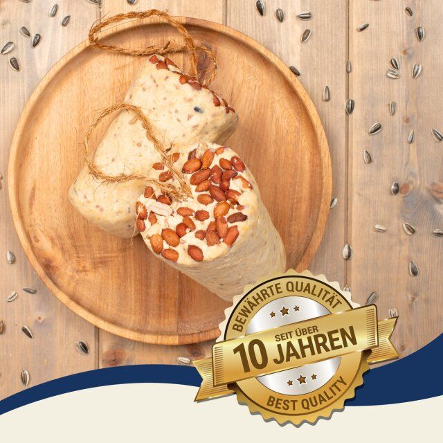 Drei Fettriegel mit Erdnüssen auf einem Holztablett. Goldene Plakette 'Bewährte Qualität seit über 10 Jahren'.