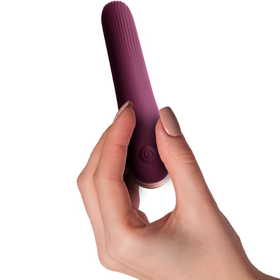 Lila Vibrator, geriffelte Oberfläche, in Hand gehalten. Mit Power-Taste. Unterteil goldfarben.