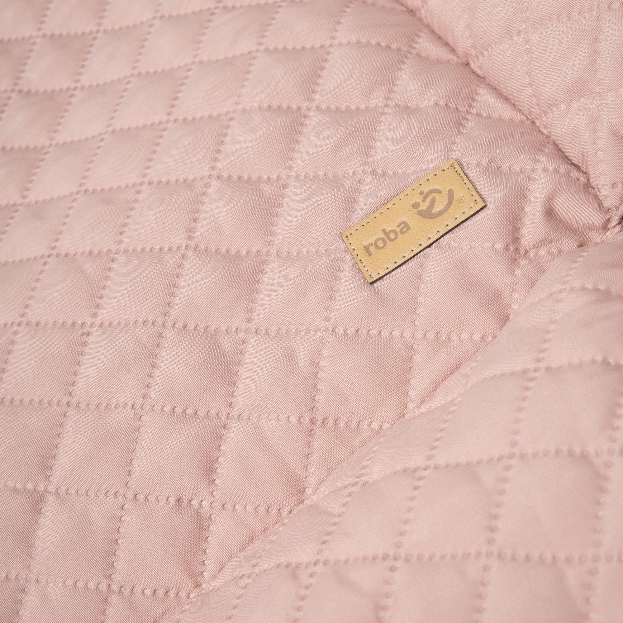 Nahaufnahme der rosa Laufgittereinlage mit Steppmuster. Kleines braunes Label mit 'roba' Logo.