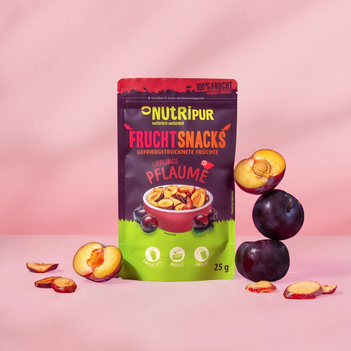 Beutel mit gefriergetrockneten Pflaumen-Snacks. Daneben Pflaumen und Pflaumenscheiben. Aufschrift: Frucht Snacks, Pflaume.