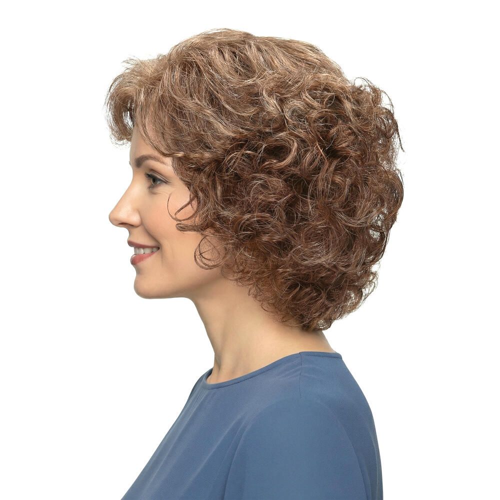 Perücke mit lockigem, braun-blondem Haar. Seitenansicht einer Frau mit blauem Oberteil. Frau lächelt.