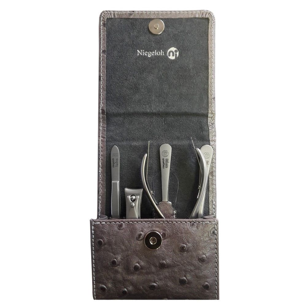 Graues Maniküre-Set in Etui mit Straußenleder-Optik. Enthält mehrere silberfarbene Werkzeuge. Marke Niegeloh.