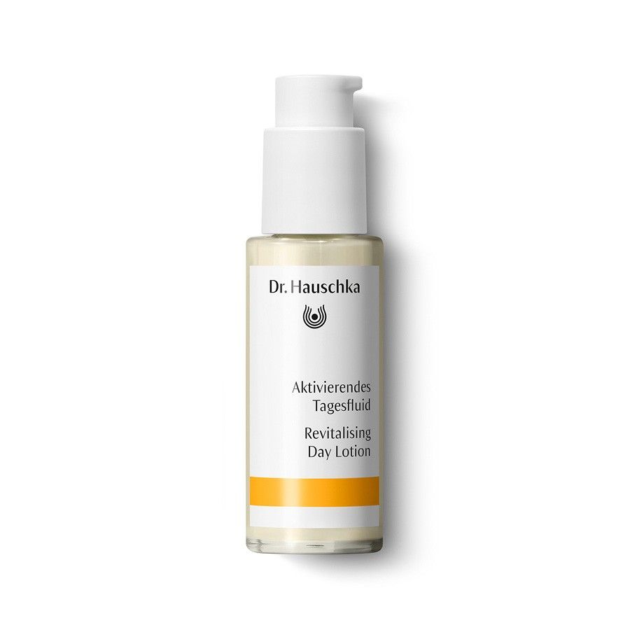 Dr. Hauschka Tagesfluid-Flasche mit Spender. Weißes Etikett mit Produktnamen und Logo. Orangefarbener Streifen.