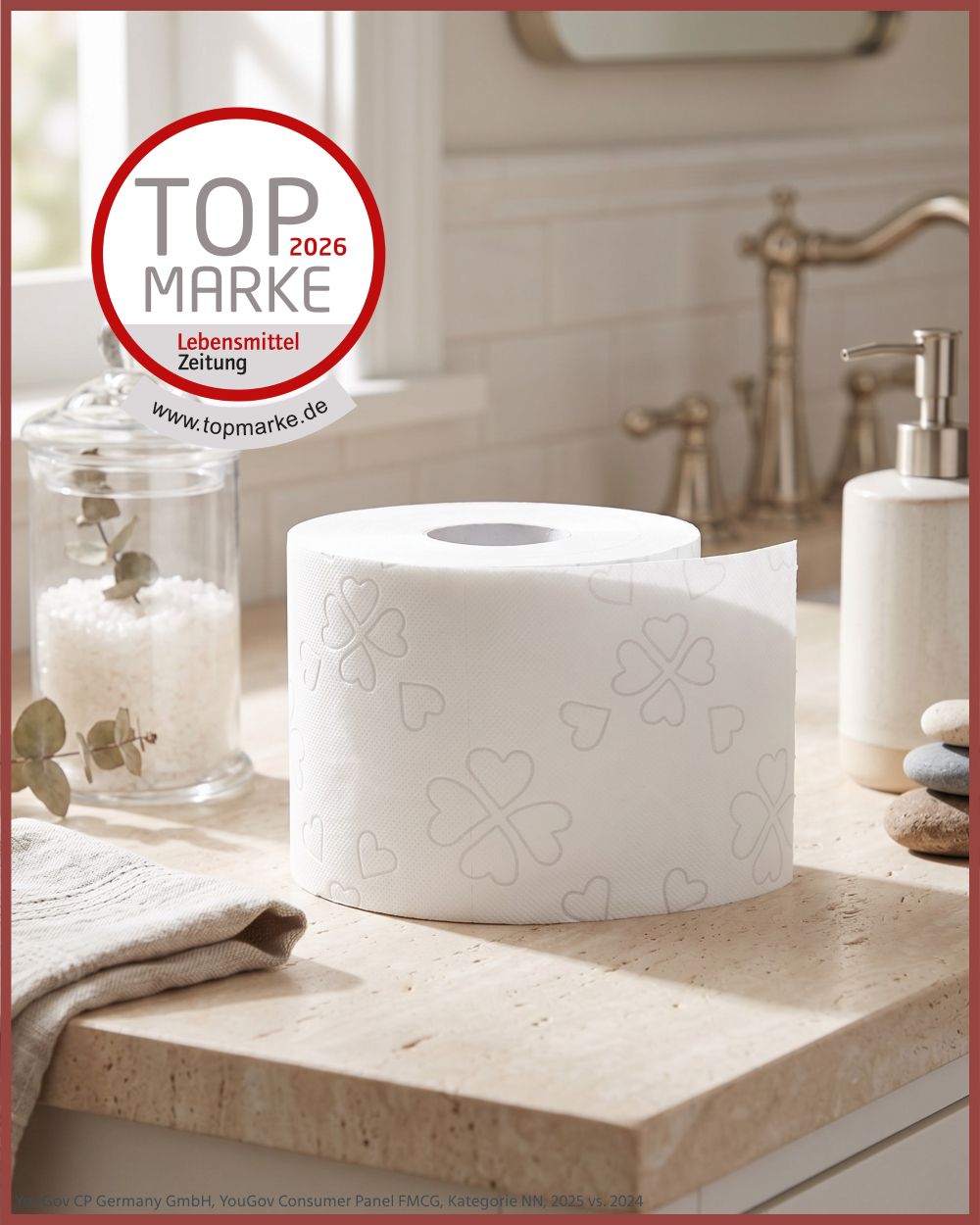 Toilettenpapierrolle mit Kleeblatt-Prägung auf einem Badezimmerwaschtisch. Auszeichnung 'Top Marke'.