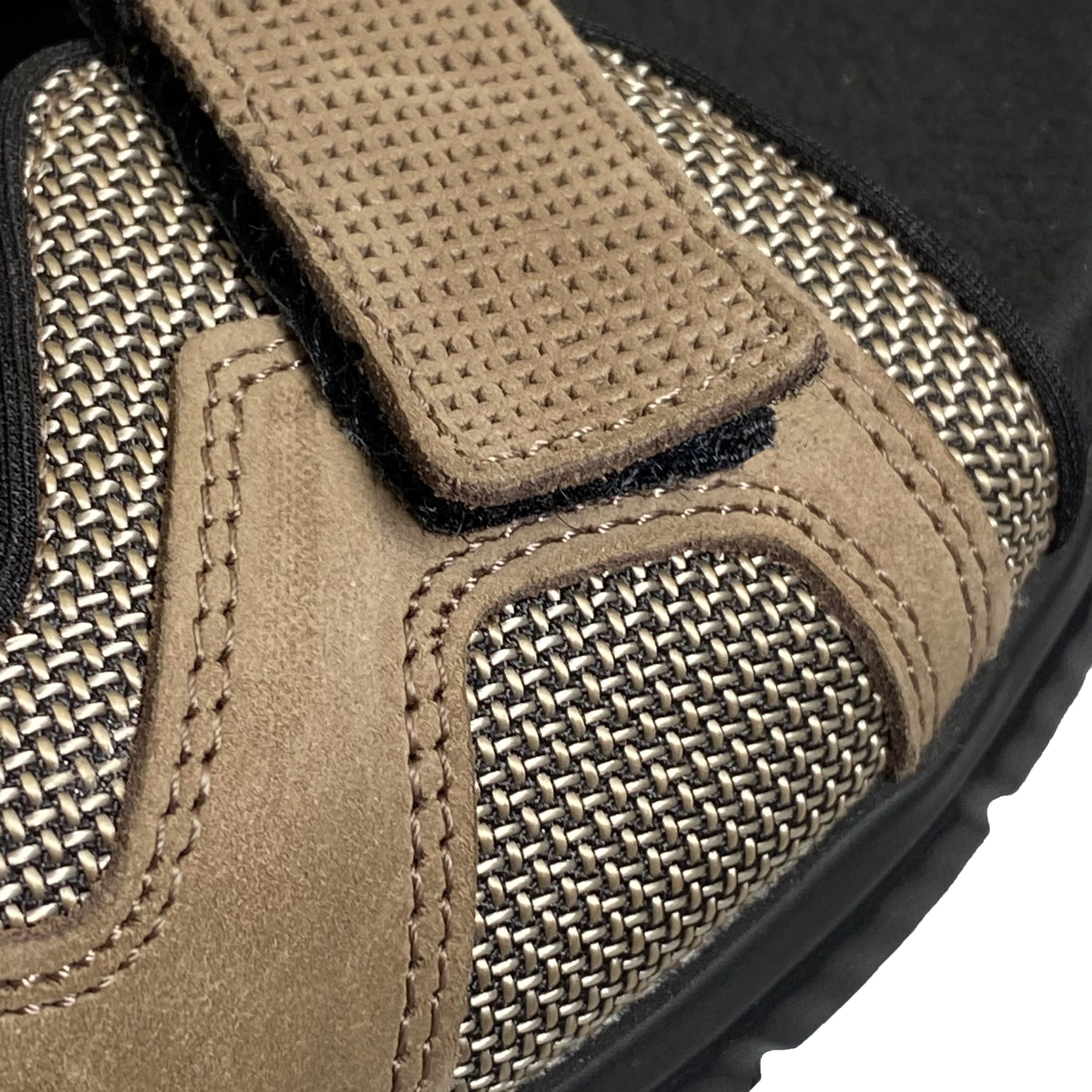 Detailansicht einer braunen Sandale. Klettverschluss, Mesh-Einsatz, braunes Leder und schwarze Sohle.