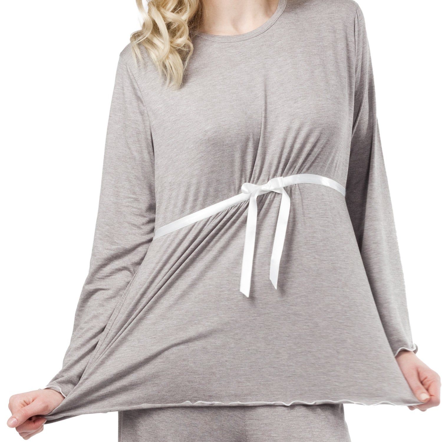 Graues Schwangerschaftspyjama-Oberteil mit weißem Bindeband. Lange Ärmel. Frau hält Stoff auseinander.